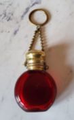 A Victorian ruby glass chatelaine scent bottle, hinged cover, suspension chain, 5cm high, c.1860