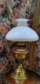 An early 20th century polished brass oil lantern with frosted shade and chimney, converted to