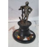 A silver coloured metal figure, of a sailor standing by an oversized anchor, pietra dura capstan