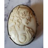 A Victorian silver mounted cameo brooch, carved with a scantily clad lady, 4.25cm high, c.1860