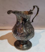 A George III silver pedestal cream jug, embossed with foliage, beaded rim, double scroll handle,