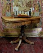 An early 19th century flamed mahogany tea table, the folding top on turned column, four splay