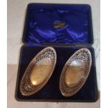 A pair of Edwardian silver boat shaped dishes, pierced sides, 14cm wide, Birmingham 1909, cased