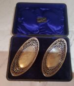A pair of Edwardian silver boat shaped dishes, pierced sides, 14cm wide, Birmingham 1909, cased