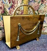 A polished brass magazine rack applied with Neoclassical ribbon tied swags, rope twist handle