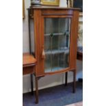 An Edwardian Sheraton Revival mahogany bow fronted display cabinet, satinwood stringing, the