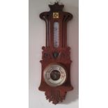 An Art Nouveau aneroid barometer, mercury thermometer, pierced and carved with stylised scrolls,