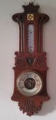 An Art Nouveau aneroid barometer, mercury thermometer, pierced and carved with stylised scrolls,