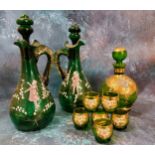 A pair of Mary Gregory green glass decanters, painted with a boy and a girl amongst snowdrops,