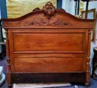 A French walnut double bed headboard, carved with crossed quivers, torch and foliage, 150cm wide