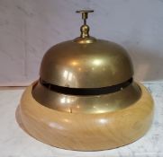 An oversized brass desk/counter bell, beech base, 21.5cm diam