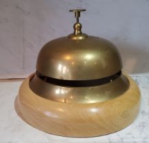 An oversized brass desk/counter bell, beech base, 21.5cm diam