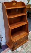 A yew waterfall bookcase, inlaid with shell patera to super structure and single drawer to base,