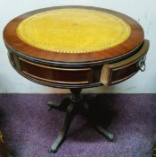 A reproduction mahogany tooled leather inlaid drum table, two short drawers to frieze, turned