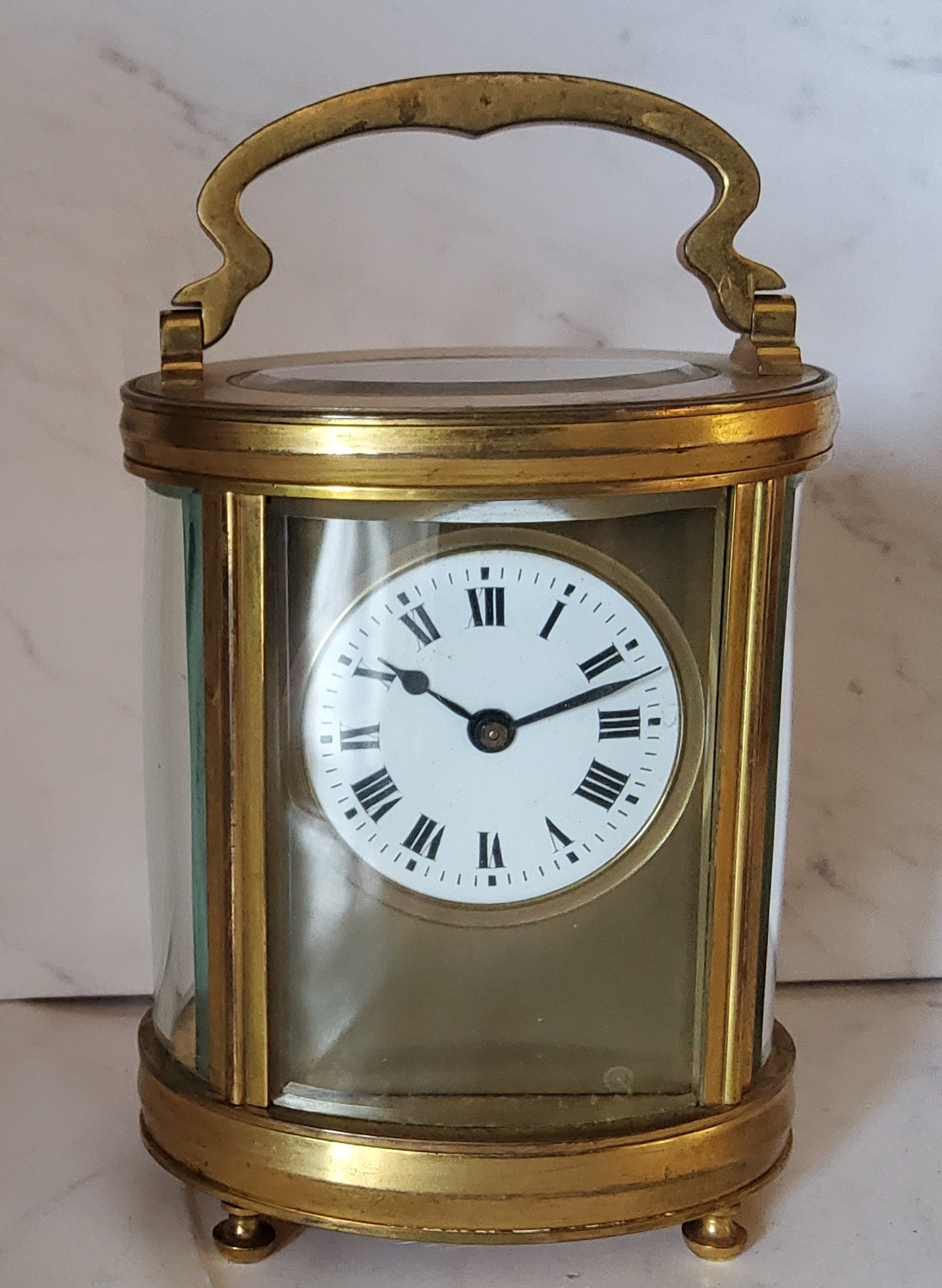 A 19th century French oval brass carriage  clock, Roman numerals, swing handle, bun feet, 16cm high,