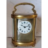 A 19th century French oval brass carriage  clock, Roman numerals, swing handle, bun feet, 16cm high,