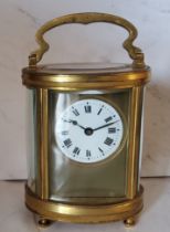 A 19th century French oval brass carriage  clock, Roman numerals, swing handle, bun feet, 16cm high,