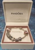 A Pandora silver charm bracelet, ten charms including silver and pink glass, clips, rabbit, school