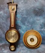 An early 20th century oak barometer, carved with demi-flowers, 23cm diam;  another, wheel barometer,