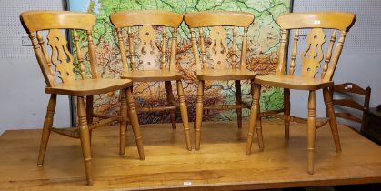 A set of four farmhouse pine dining chairs, spindle and pierced splat bow backed
