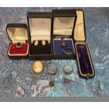 A yellow metal mounted cameo; a pair of cameo earrings; a silver ring set with a central oval purple