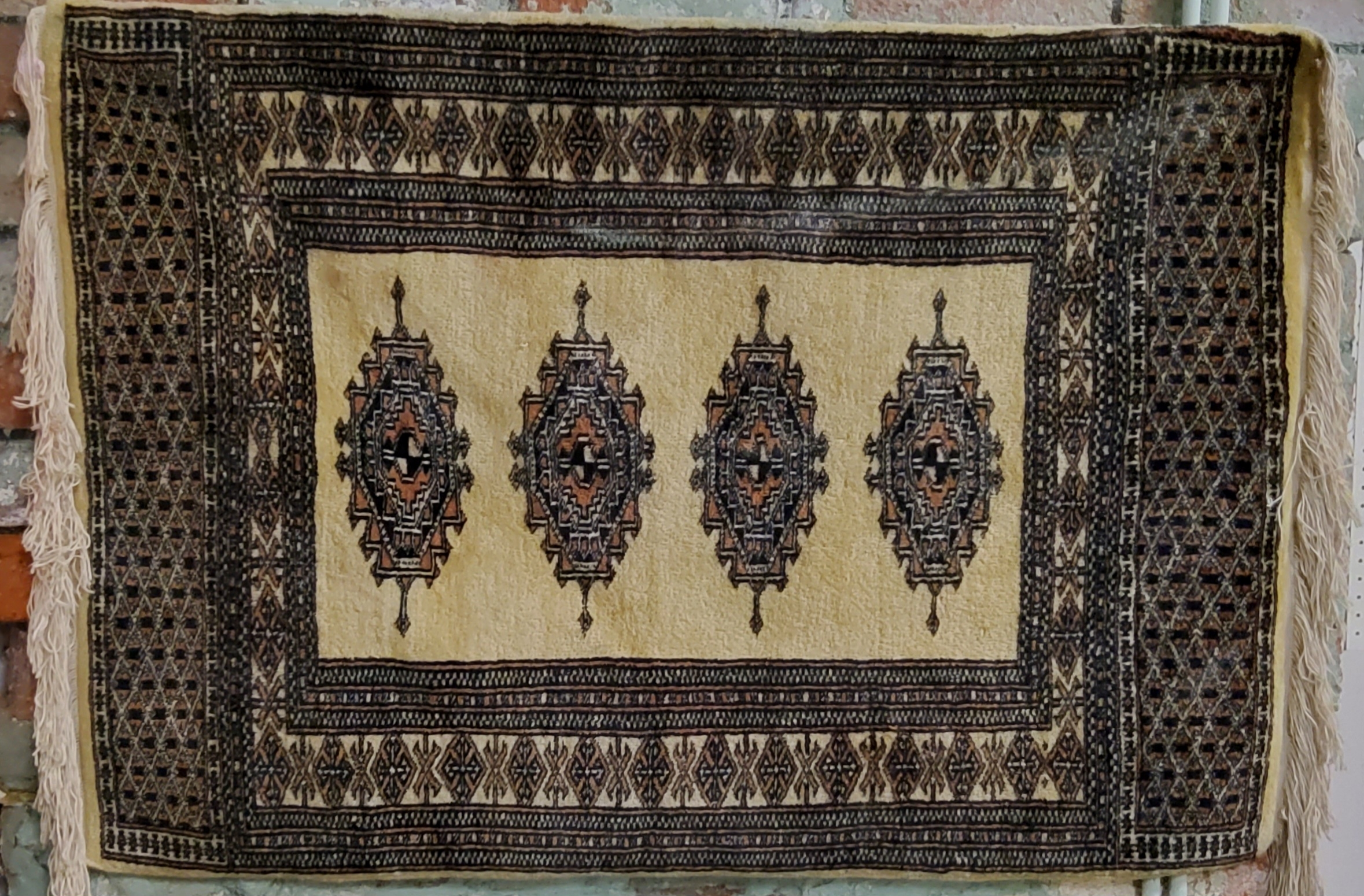 A Pakistani Bokhara rug in vivid tones of gold, black and light brown