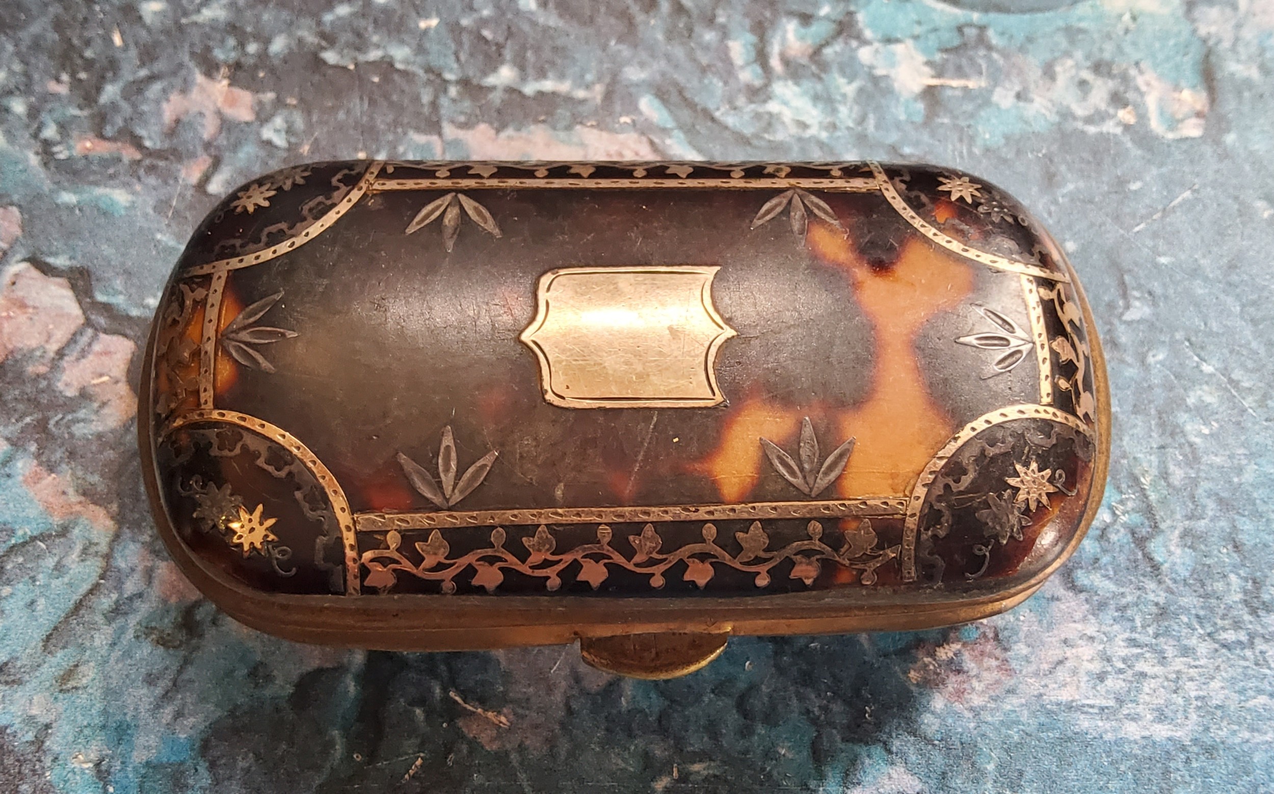 A 19th century tortoiseshell and gold coloured metal pique purse, with shield cartouche, 6.5cm wide,