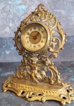 A Victorian brass mantel clock, the dial with Arabic numerals, pierced leafy scroll and cherub case,