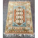 A Turkish Kazak rug with geometric panels in tones of olive green, terracotta and duck egg blue,