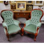 A pair of Victorian mahogany stuffed-over arm chairs