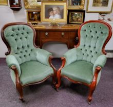 A pair of Victorian mahogany stuffed-over arm chairs