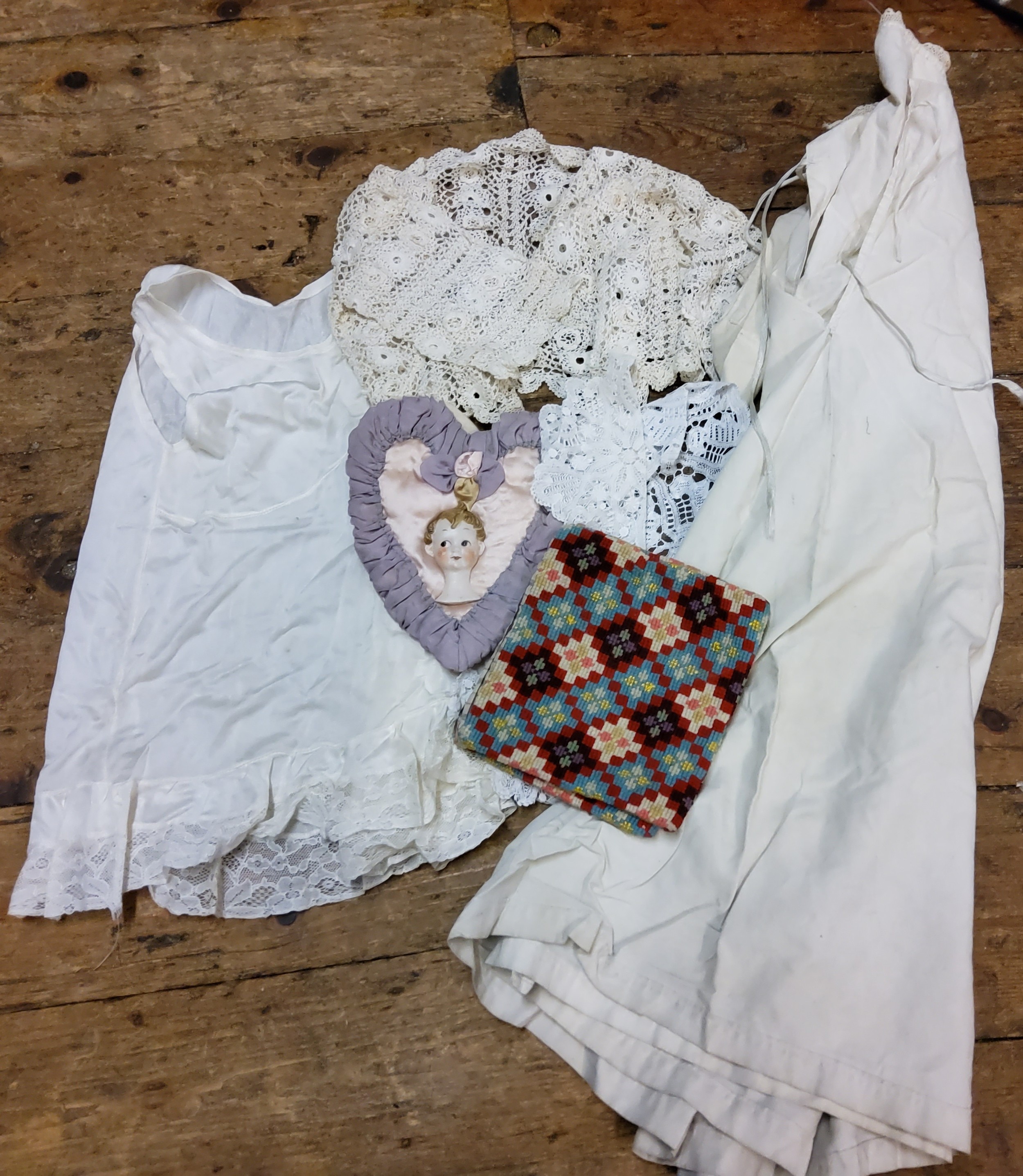 Textiles - a Victorian cotton night gown;  silk and lace child's clothes;  a heart shaped needle