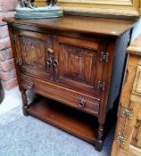 A Jaycee oak side cabinet, two linen fold doors above drawer, shelf stretcher, 86cm high, 79cm wide,