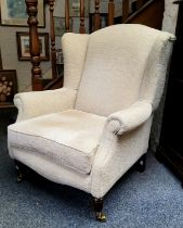 A Victorian style wingback armchair, tapered legs, upholstered in cream