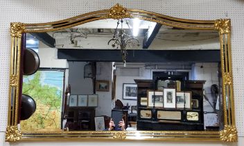 A substantial gilt 'antique' arched mirror, acanthus capped corners with foxed mirror bevelled