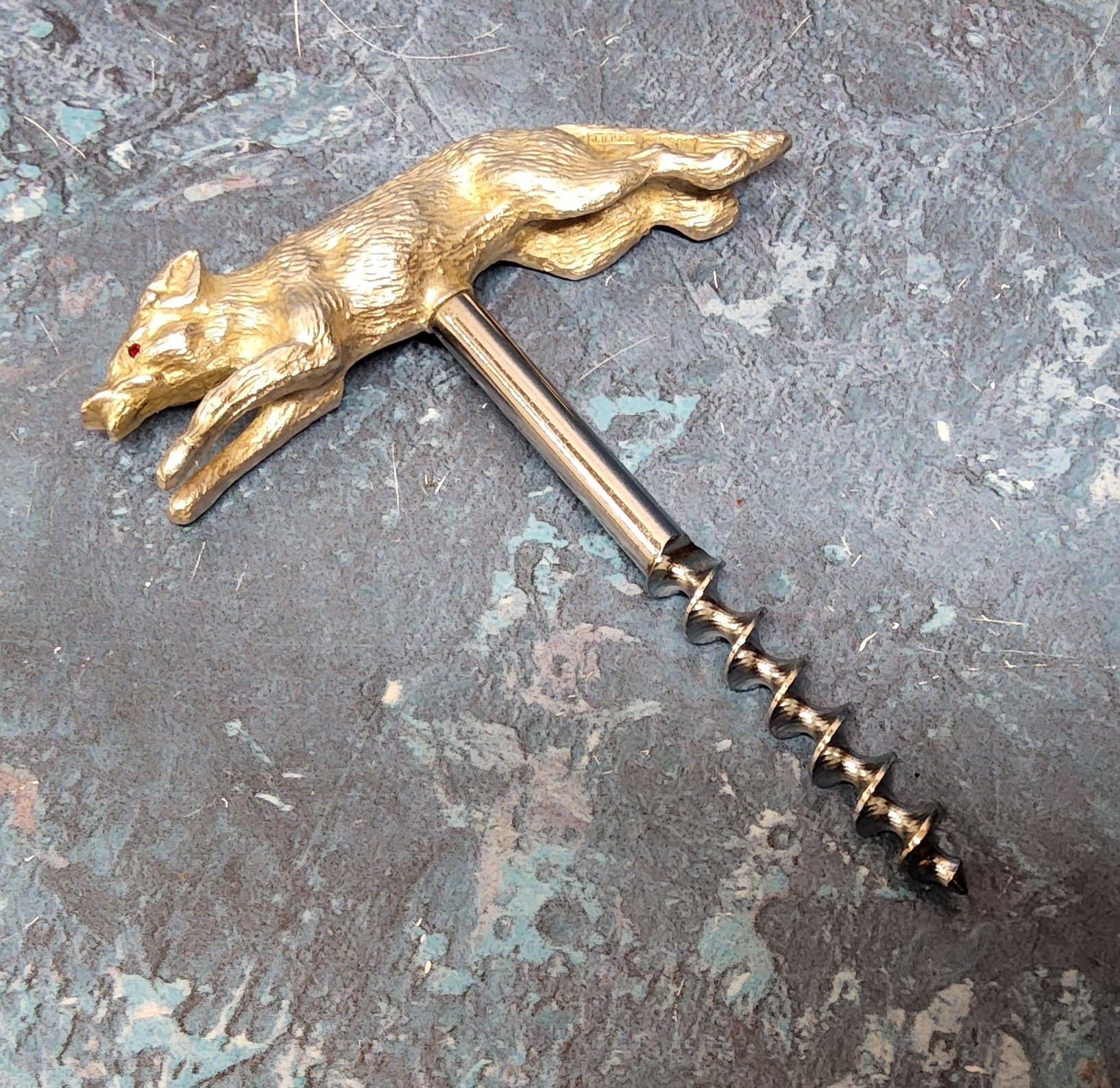 A mid century corkscrew, the silver handle in the form of a fox, the eyes set with red stones, J B
