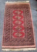 A late 19th / early 20th century century Iranian Baluch rug in tones of red and black