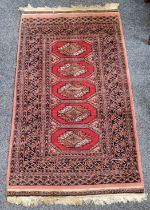 A late 19th / early 20th century century Iranian Baluch rug in tones of red and black