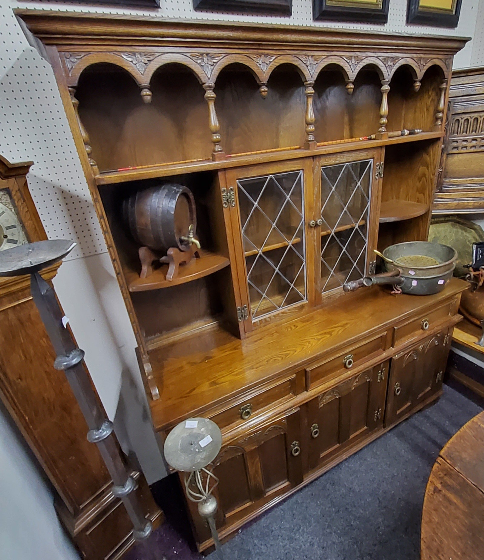 An Old Charm type oak Jacobean Revival kitchen dresser, oversailing ogee cornice above two astagal