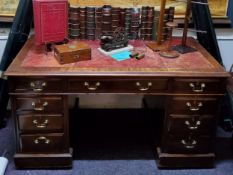 A tooled leather inlaid twin pedestal mahogany desk, three drawers to frieze above two banks of