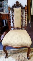 A Victorian walnut nursing chair, leafy carved cresting, upholstered splat, flanked by turned