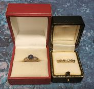 A 9ct gold ring, claw set with a round blue stone cabochon, the shoulders set with diamond chips,