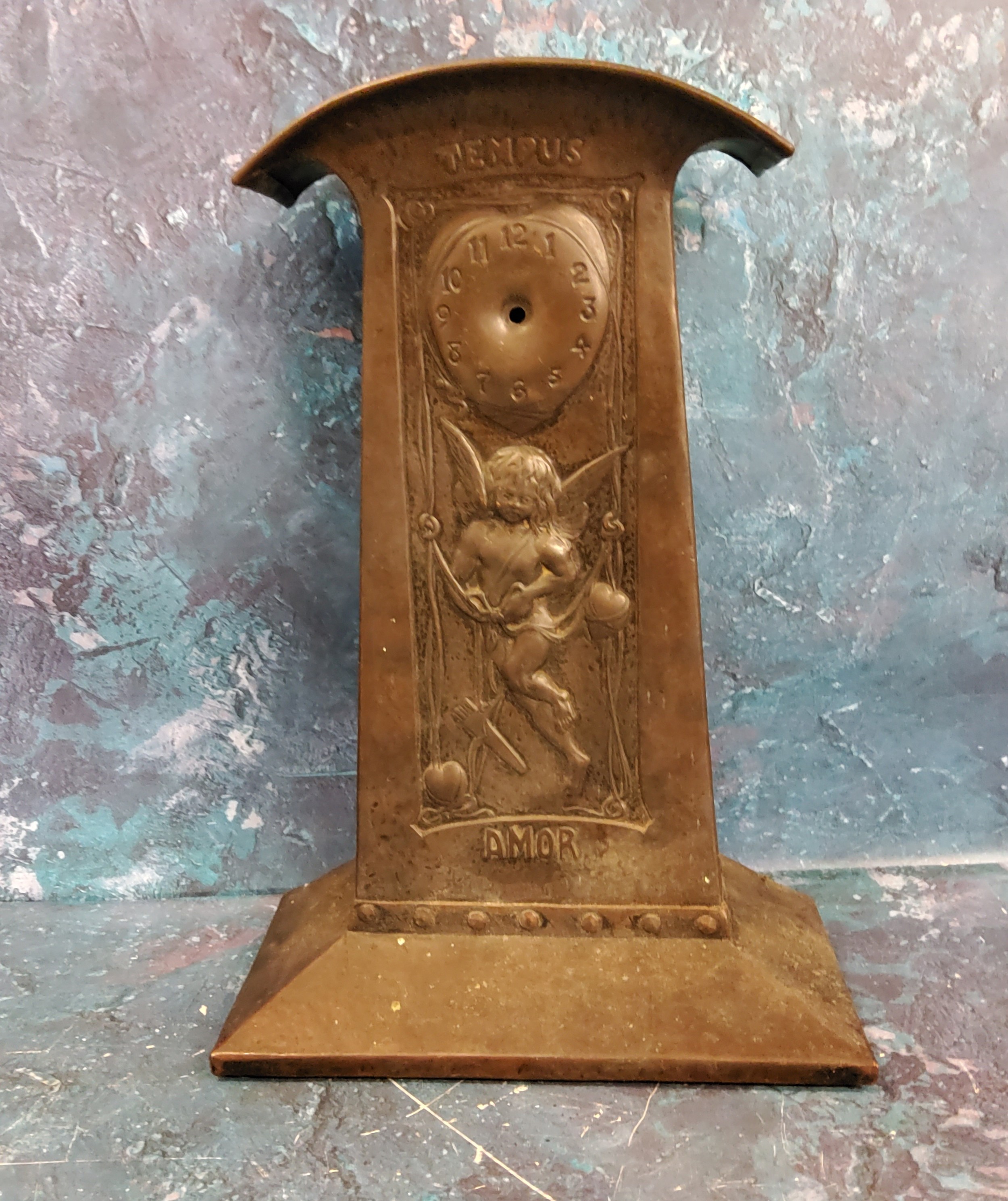 An Art Nouveau pewter mantel clock, in the Liberty manner, embossed with Cupid inscribed Tempus