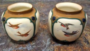 A pair of Royal Worcester Hadley style vases,  moulded with panels and painted with birds in flight,