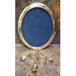 A silver oval photograph frame, 24.5cm high, Birmingham 1916; a pair of Edwardian silver napkin