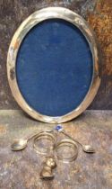 A silver oval photograph frame, 24.5cm high, Birmingham 1916; a pair of Edwardian silver napkin