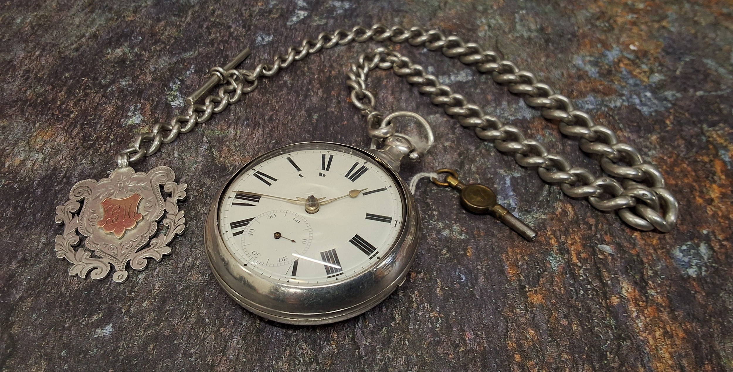 A silver pair cased pocket watch, inscribed James Edge 1829, with key; a silver Albert chain and