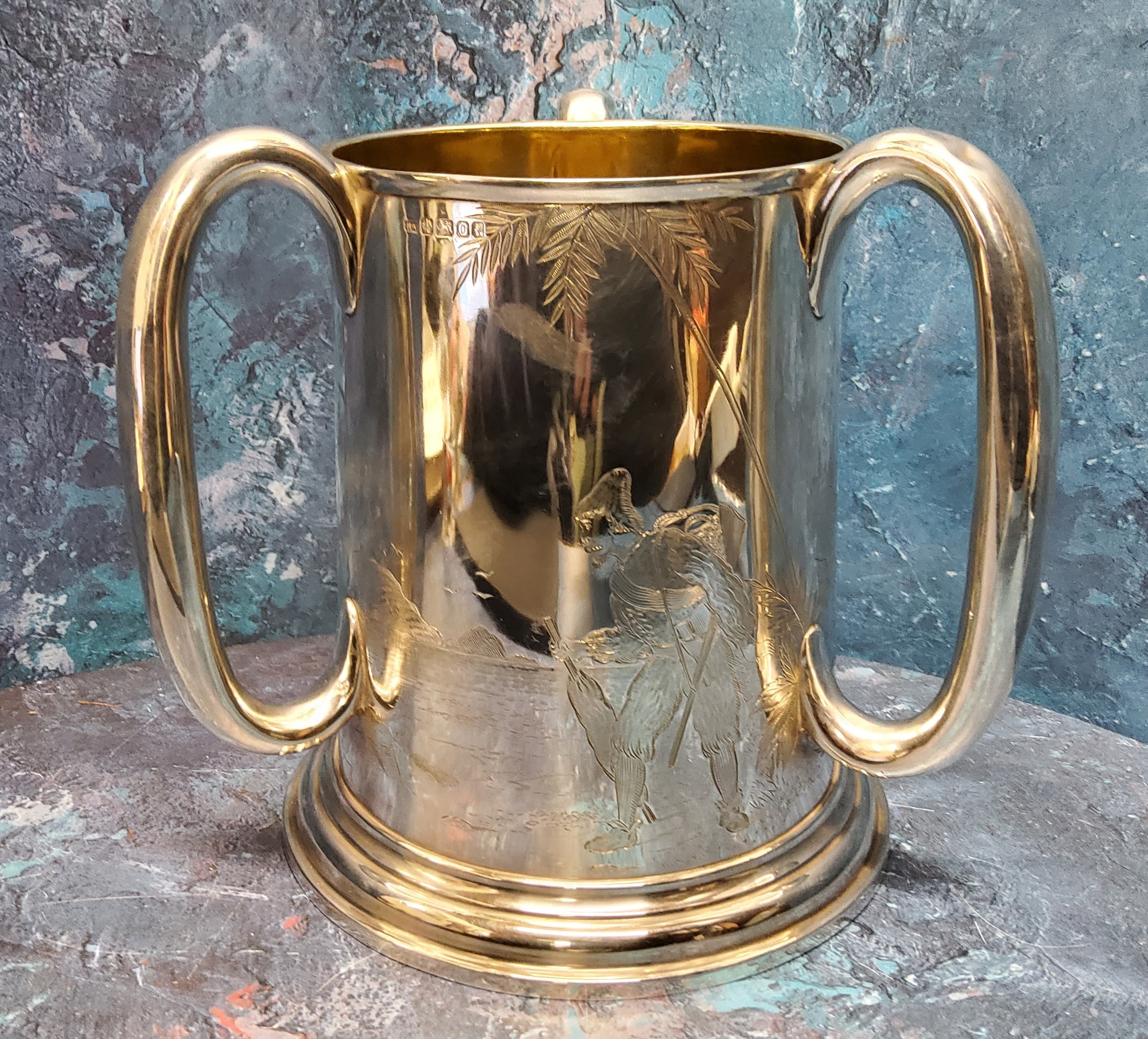 A Victorian silver spreading cylindrical tyg, loop handles, engraved with a continuous scene with