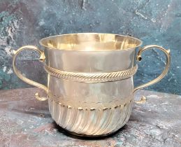 A late 17th century silver porringer, wrythen fluted and engraved, banded girdle, scroll handles,