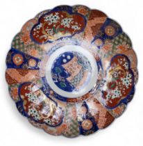 A Japanese Imari shaped circular charger, decorated with alternating panels of blossoming